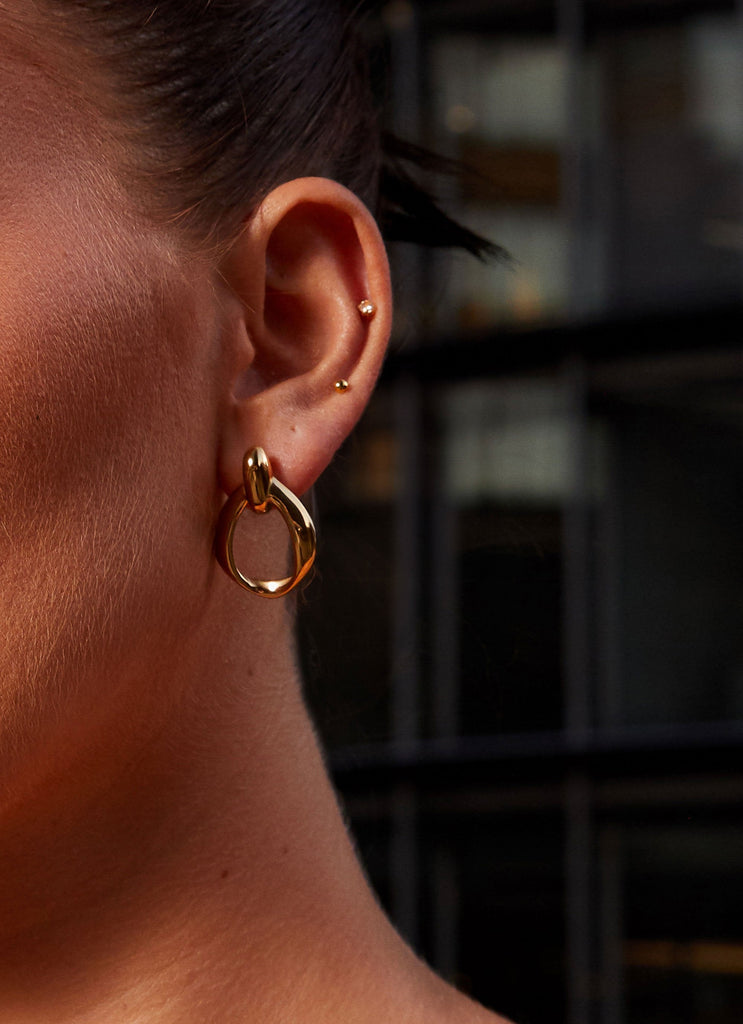 Womens Folded Chain Earrings in the colour Gold in front of a light grey background