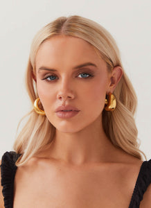 Womens Bon Voyage Hoop Earrings in the colour Gold in front of a light grey background