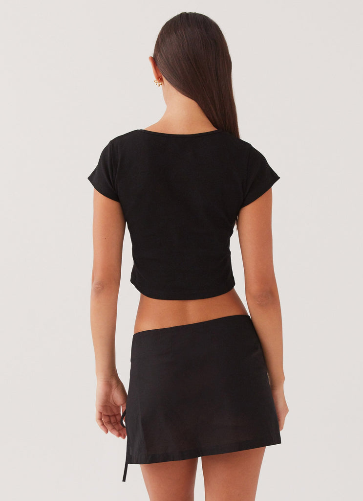 Womens Summer Retreat Mini Skirt in the colour Black in front of a light grey background