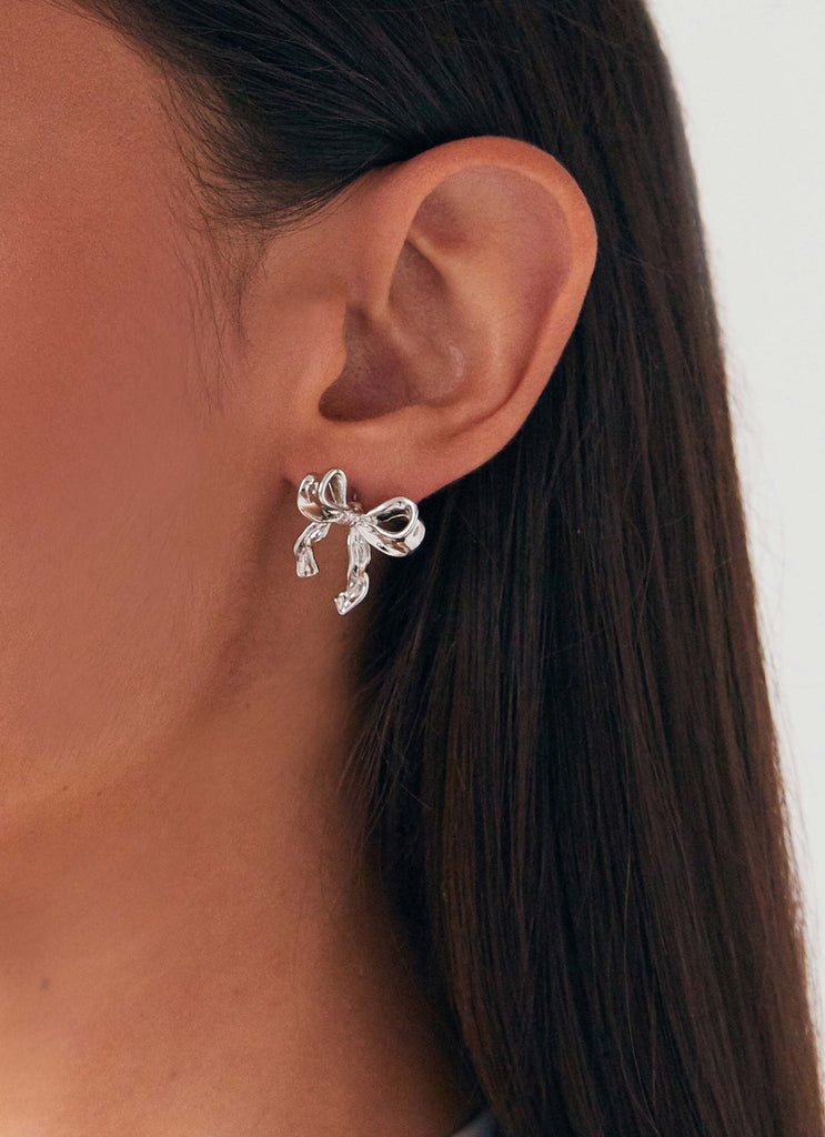 Womens Kindra Mini Bow Earring in the colour Silver in front of a light grey background