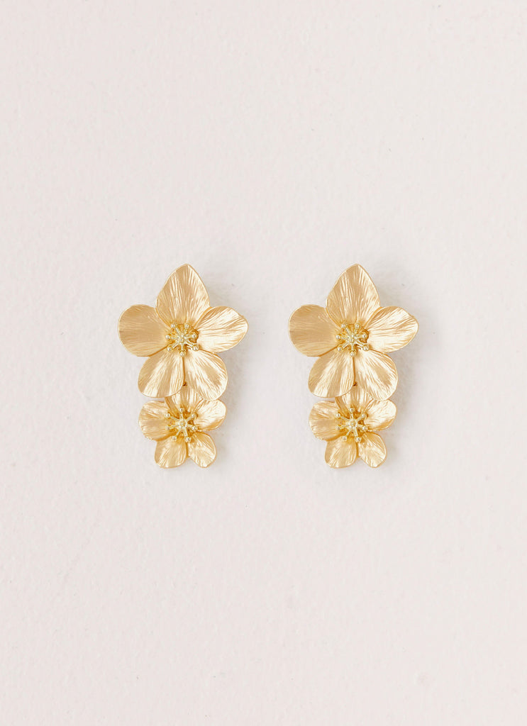 Womens Lola Love Flower Earrings in the colour Gold in front of a light grey background