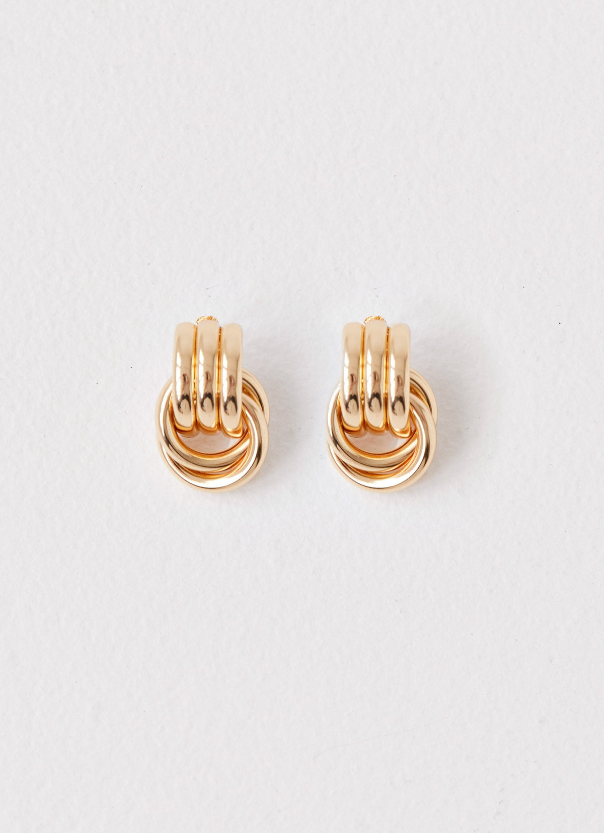 Womens Bold Step Cuff Earrings in the colour Gold in front of a light grey background