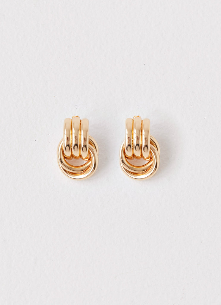 Womens Bold Step Cuff Earrings in the colour Gold in front of a light grey background