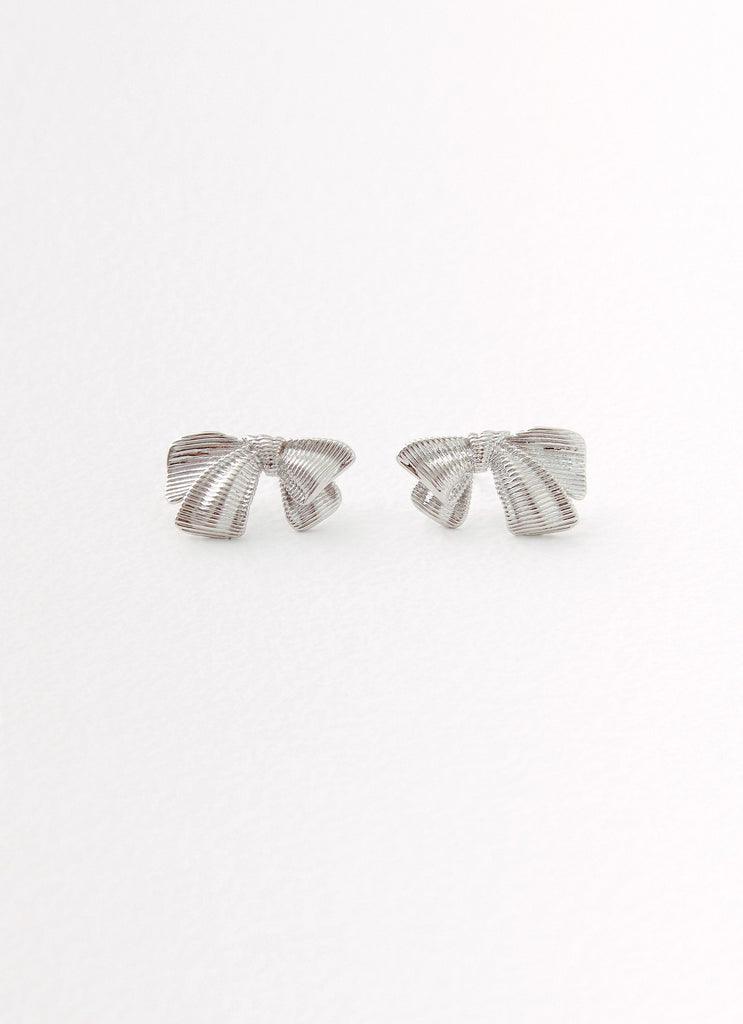 Womens Kiyah Bow Earrings in the colour Silver in front of a light grey background