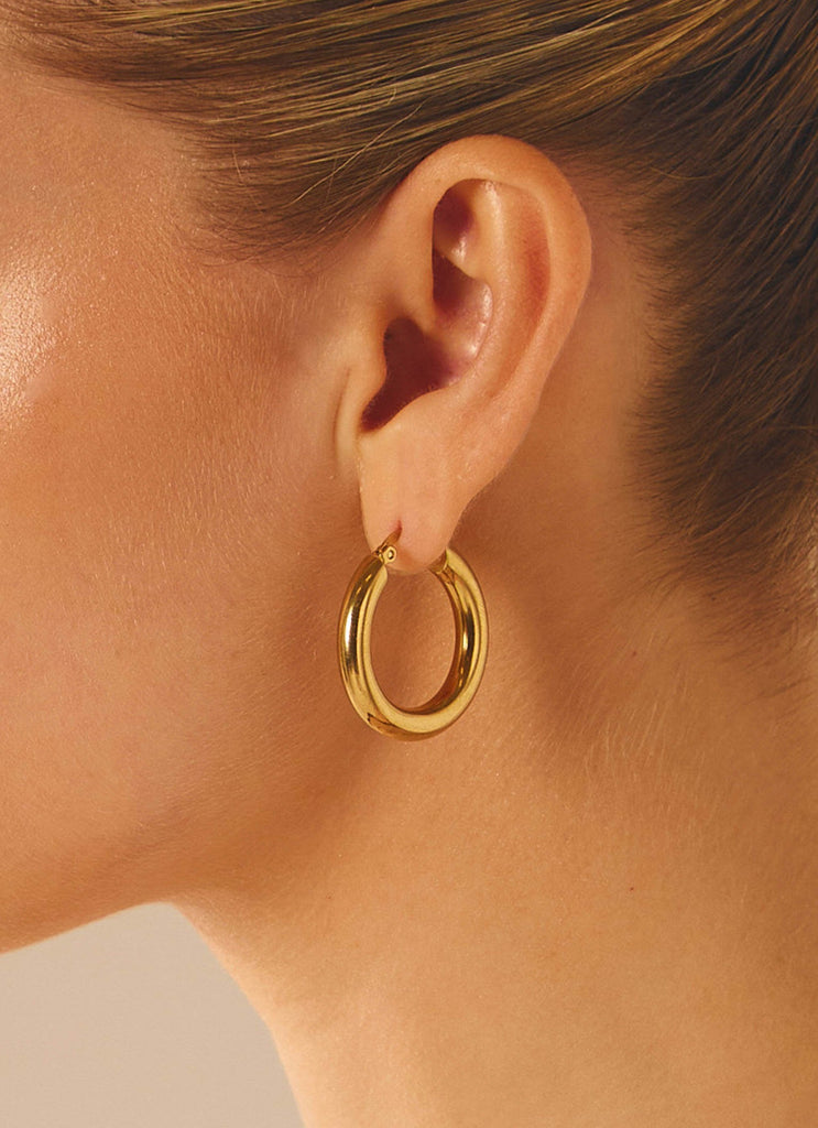 Womens Keep Frontin Hoop Earrings in the colour Gold in front of a light grey background