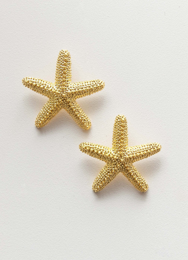 Womens Geneve Starfish Earring in the colour Gold in front of a light grey background